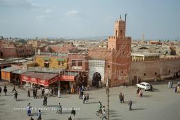 Image du Maroc Professionnelle de  Le fidèles accèdent à la Mosquée Kharbouche pour la prière d'Al Asr, cette mosquée située au bout de la fameuse place Jemaa El Fana à sa gauche l'entrée du souk Semmarine et à droite le Derb Dabachi un important passage de la médina de Marrakech, la ville touristique du Maroc. La 4L (voiture Renault 4) est bloqué par un sabot à cette époque déjà, il était strictement interdit de stationner tout le long du mur de la mosquée d'ailleurs plusieurs panneaux le rappel. Jeudi 19 Mai 1988. (Photo / Abdeljalil Bounhar) 